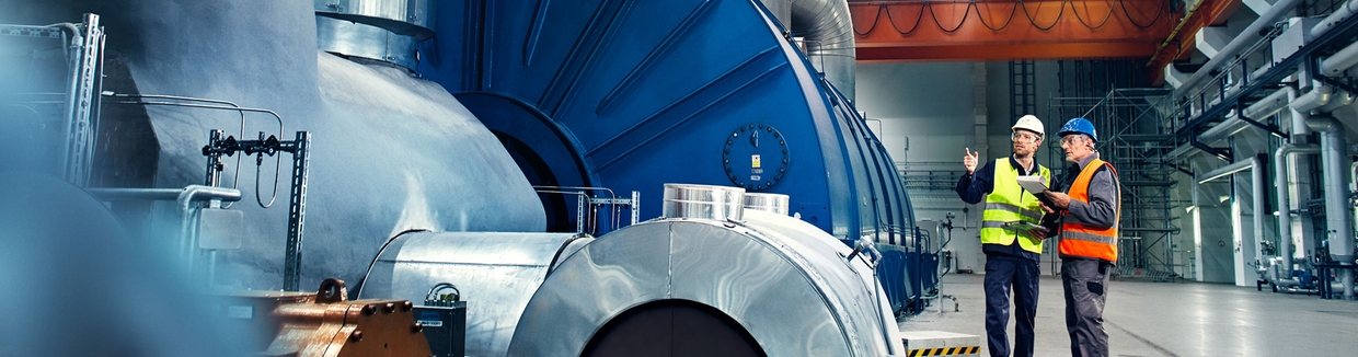 Foto di un tecnico davanti alla turbina di una centrale elettrica